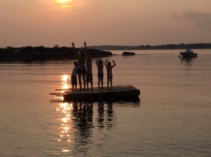 me and the kids silhouetted on a floating dock at sunset